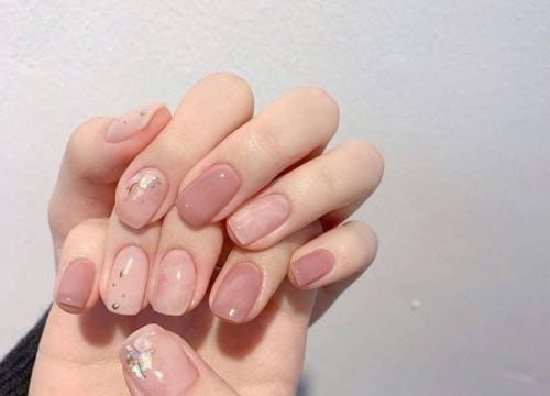 Gel manicure in een zachte nude tint met een subtiele glinstering.
