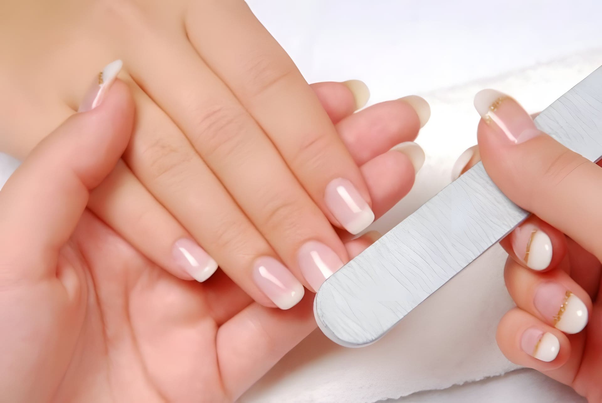 Manicure in bewerking: nagels worden gevijld en gebufd tot een gladde, natuurlijke finish.