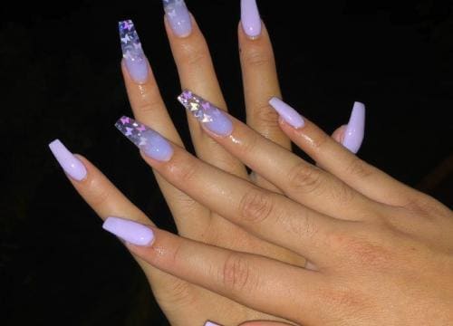 Nail art met een glitterverloop in lila tinten op langwerpige nagels.